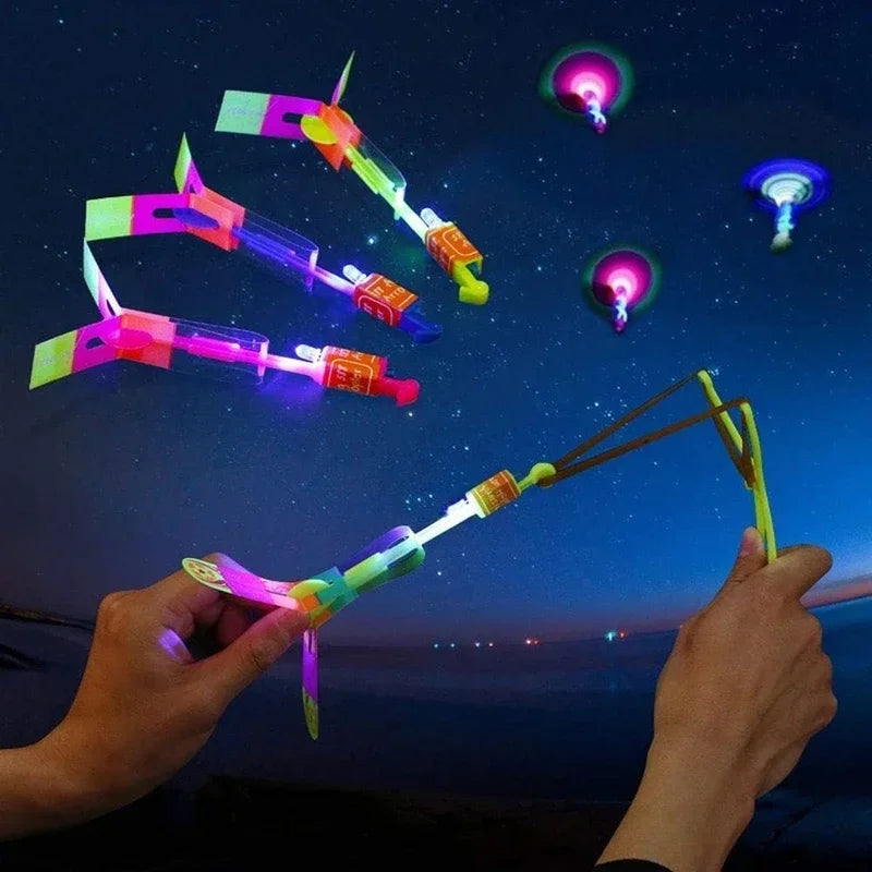 Cohete helicóptero LED con flecha luminosa — Juguete volador con catapulta de goma para niños y adultos